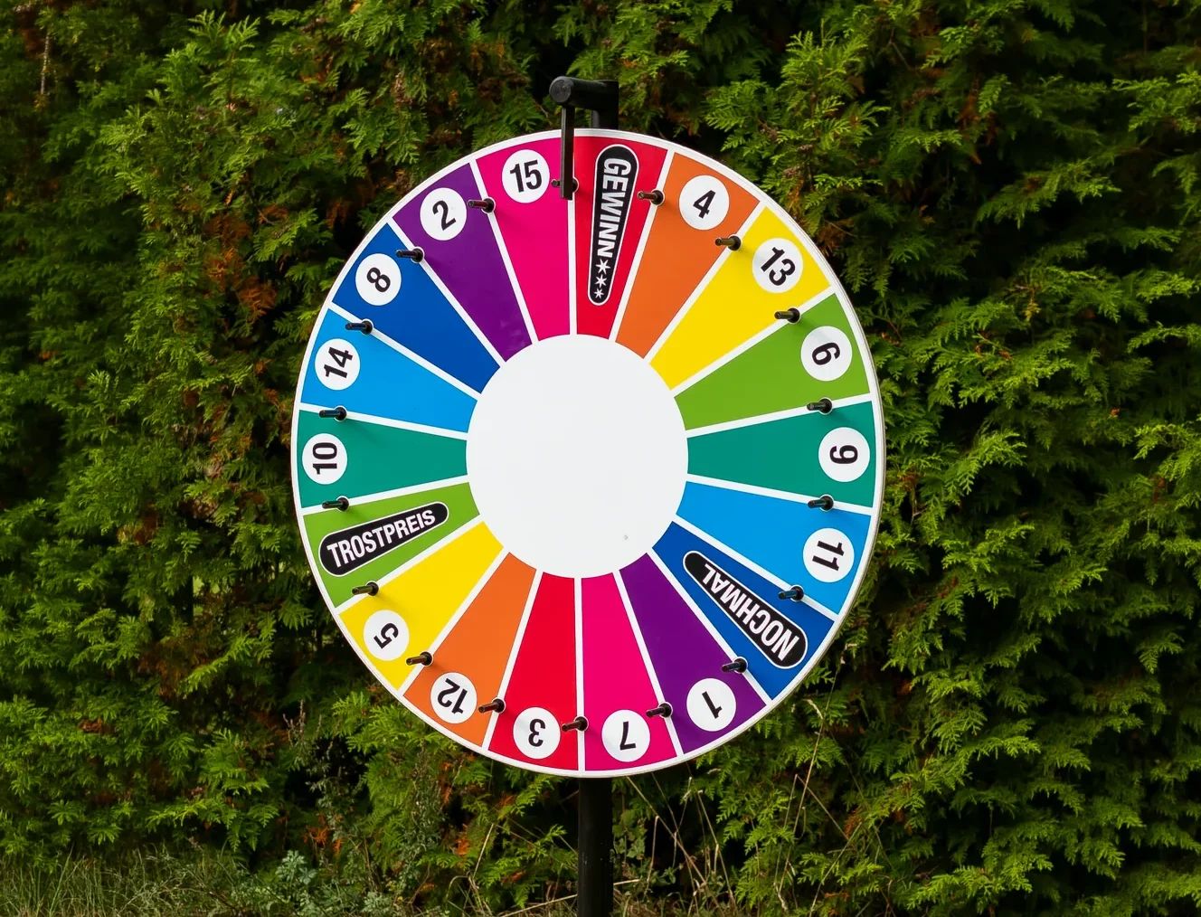 Buntes Glücksrad mit Zahlenfeldern vor einer Hecke – zum Ausleihen für EVSE-Kunden
