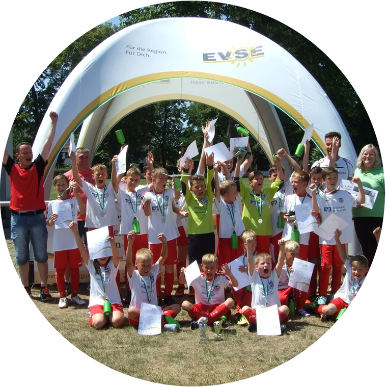 Kinder-Fußballteams jubeln beim EVSE-Fußballturnier vor dem EVSE-Zelt