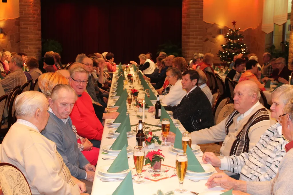 Seniorinnen und Senioren an festlich gedeckter Tafel bei der Weihnachtsfeier in Ralbitz-Rosenthal