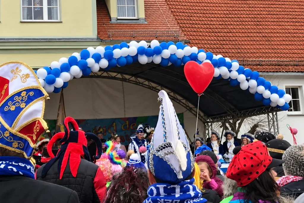 Kostümierte Karnevalisten in Blau-Weiß vor der Bühne beim Wittichenauer Karneval